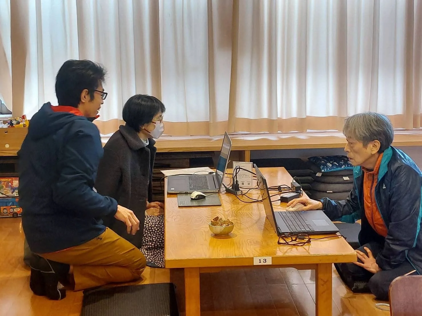 和室でパソコン作業をする人々