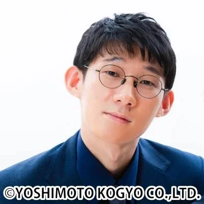 眼鏡をかけた短髪の東洋系男性が青いスーツを着用しているポートレート写真