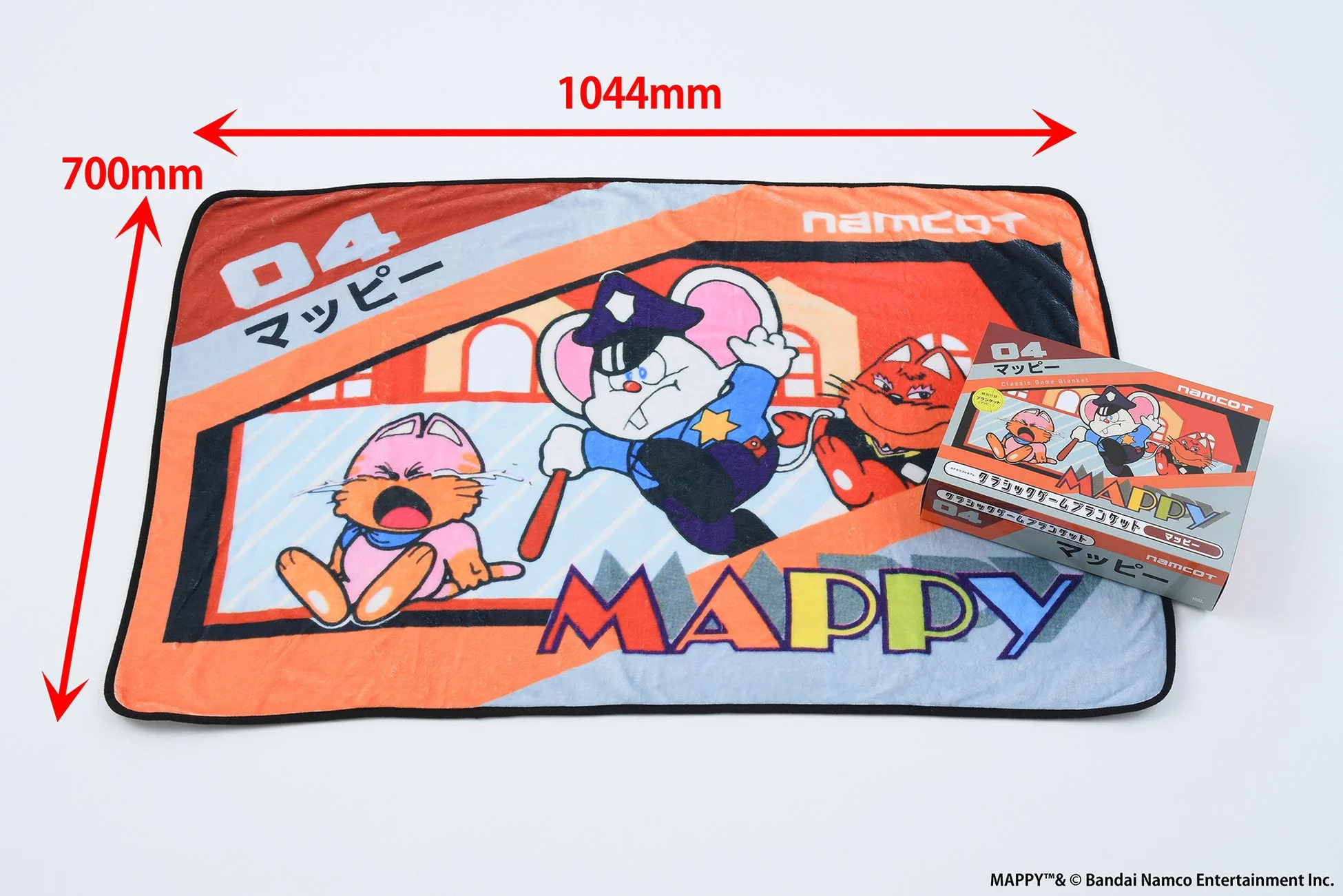 ナムコットのレトロゲーム「マッピー」のキャラクターがデザインされたブランケットとそのパッケージが写っています。警察官のネズミ「マッピー」と敵のネコたちが描かれており、サイズは700mm×1044mmです。