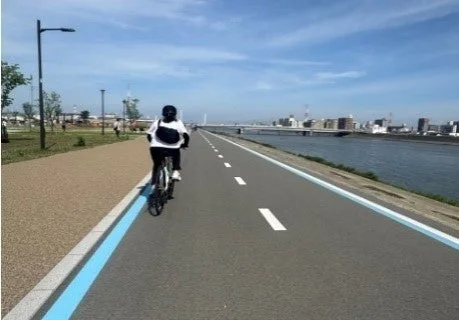 河川敷をサイクリングする人