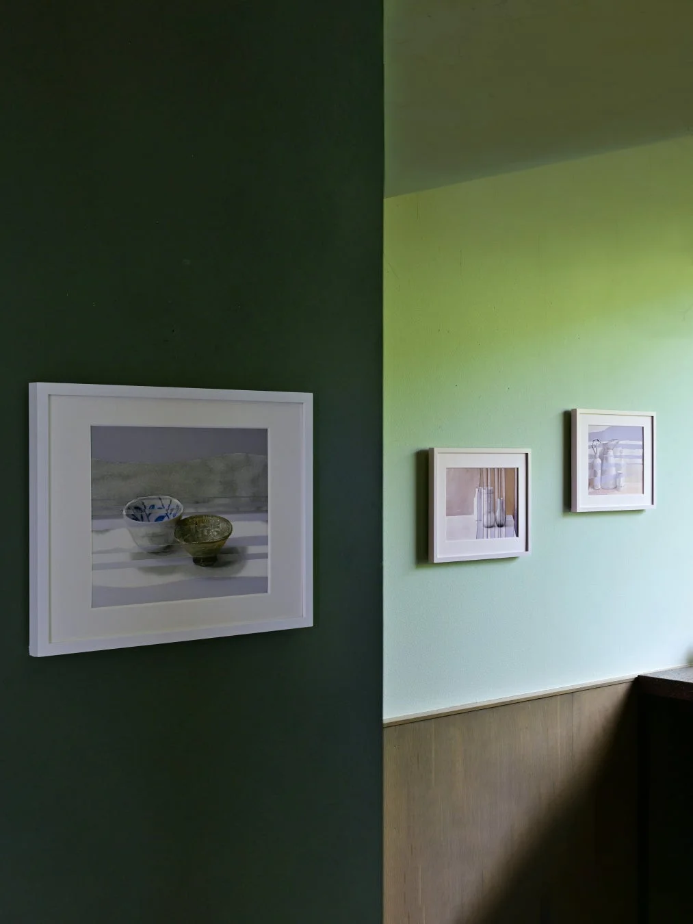 異なる緑色の壁に絵画が飾られた部屋のインテリア