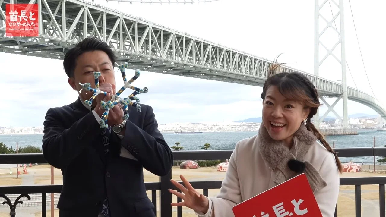 明石海峡大橋を背景に、楽しげな様子の淡路市長とMC