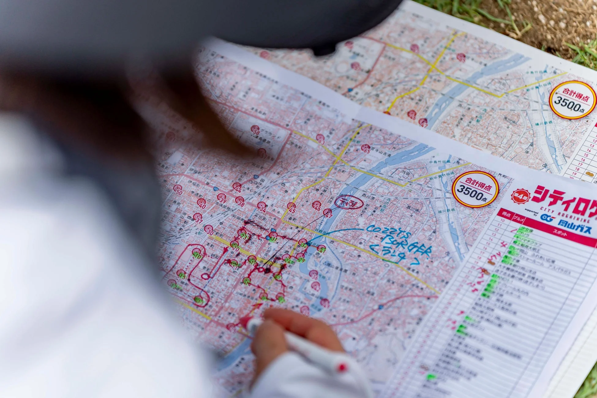 地図をペンでなぞりルートを計画している手元