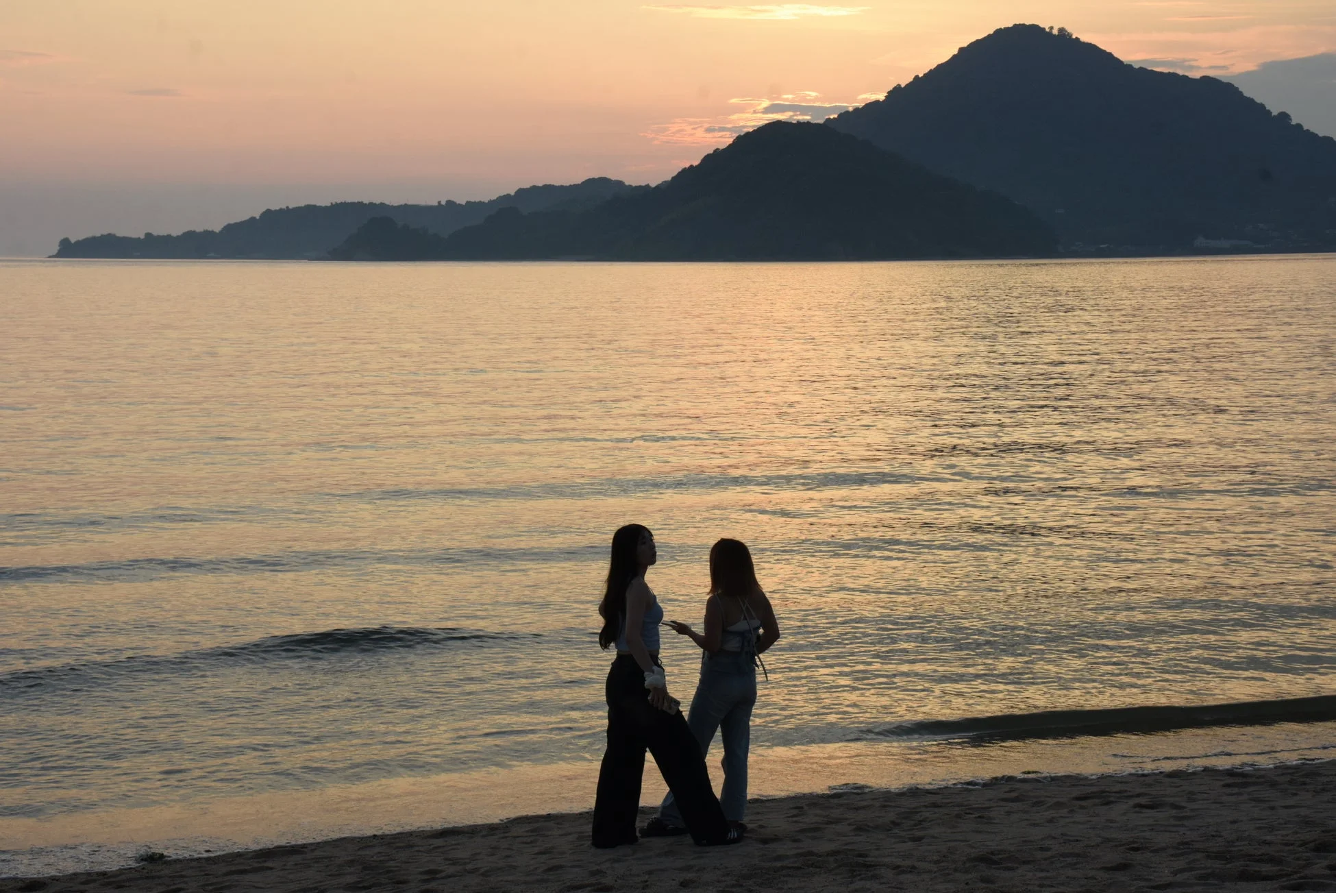 夕暮れのビーチでリラックスする二人の女性