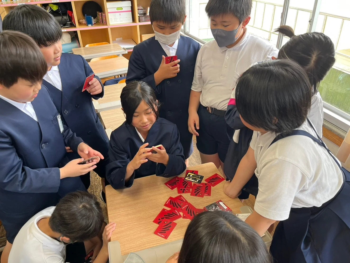 教室でカードゲームを楽しむ子どもたち