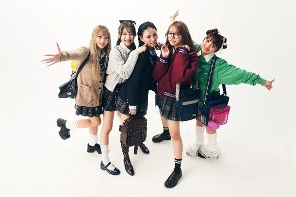 白い背景の前で、制服風の衣装を着た5人の若い女性が楽しそうにポーズをとっている集合写真です。それぞれ異なるスタイルの制服ファッションを着こなしています。