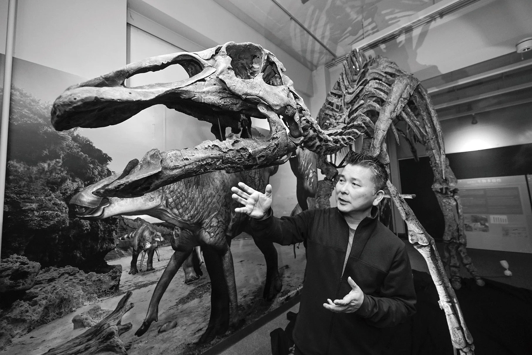 カムイサウルス全身骨格の前で語る小林快次さん