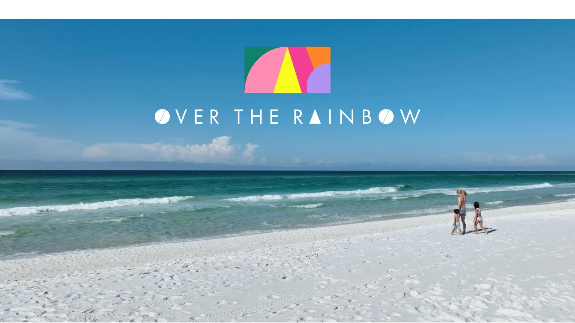 ビーチで母親と二人の子供が歩く風景と「OVER THE RAINBOW」のロゴ