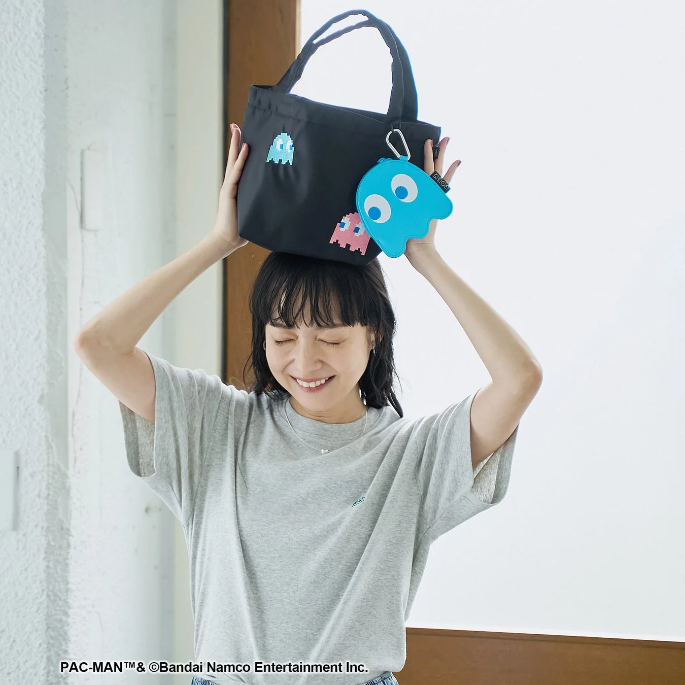 パックマンのトートバッグを持つ女性