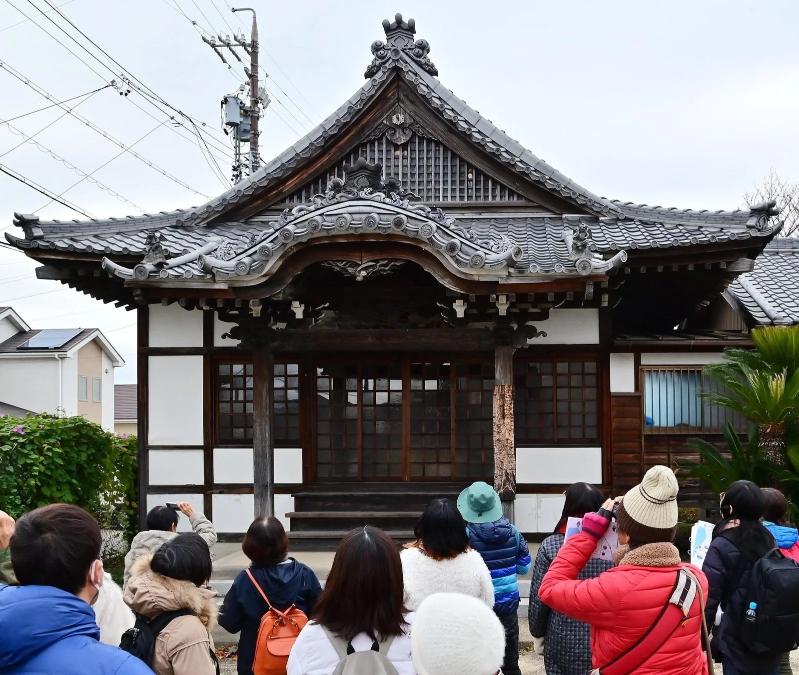 瓦屋根の日本建築を見学する人々