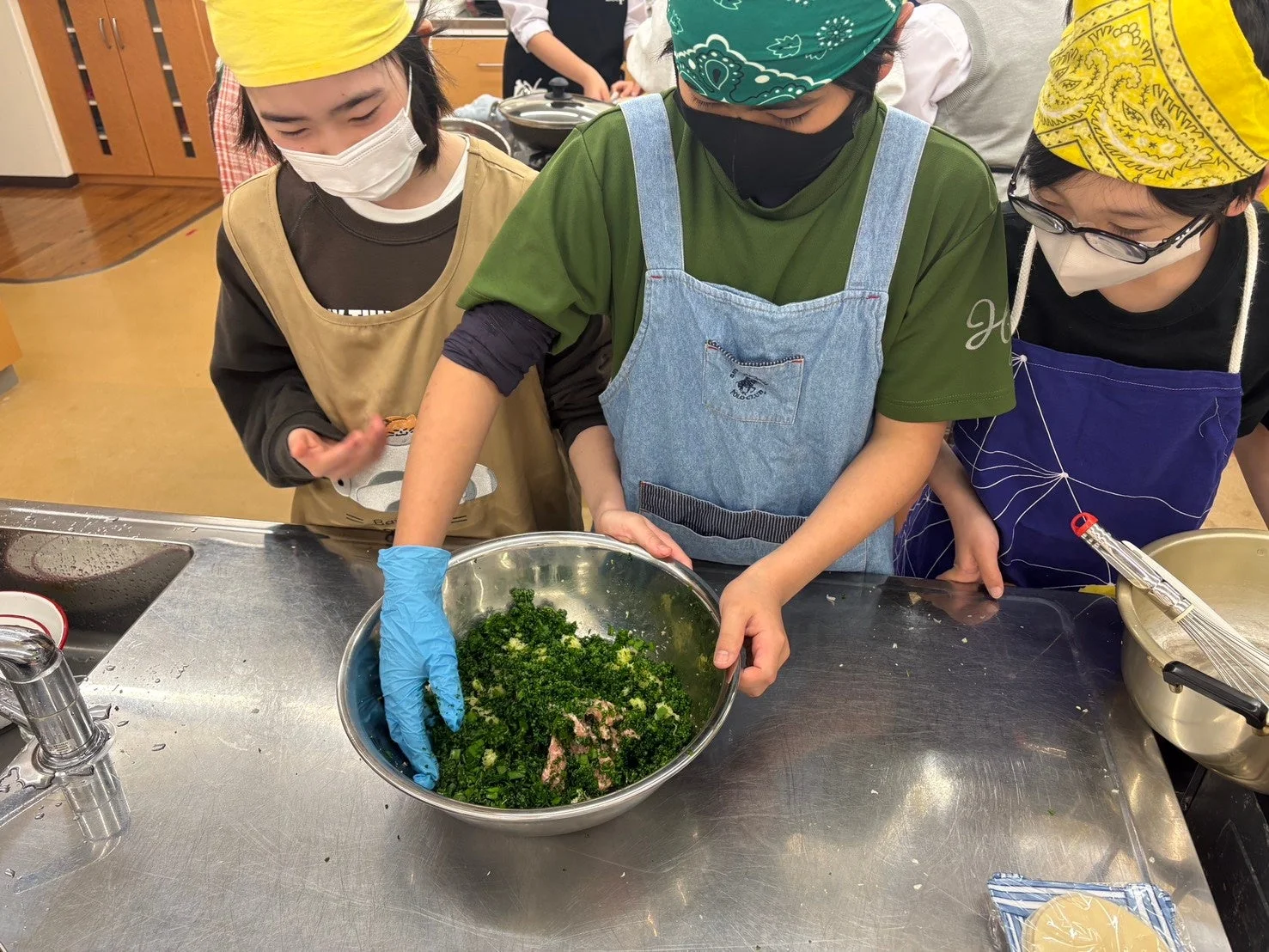 子供たちが刻んだ野菜とひき肉を混ぜる料理教室の様子
