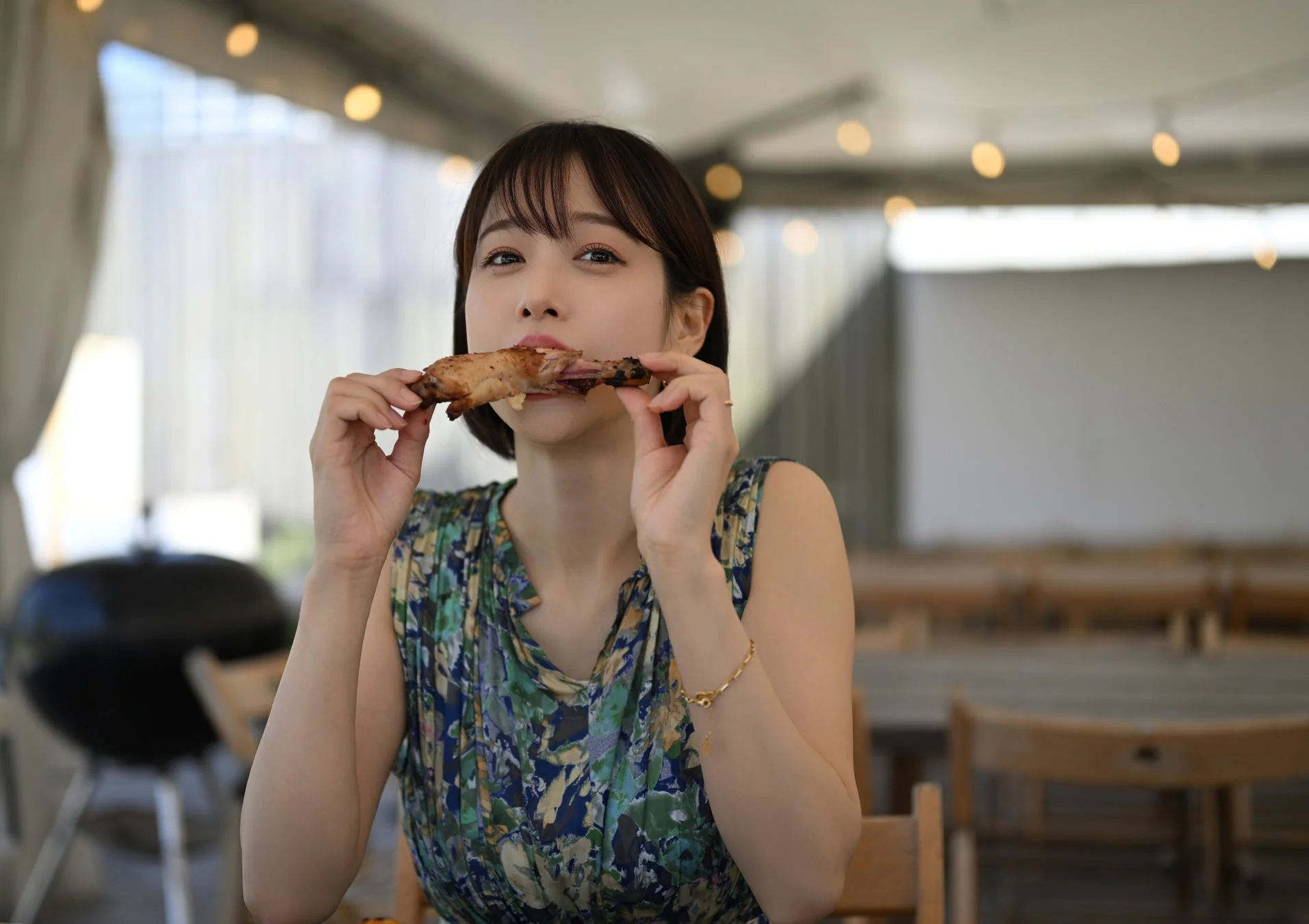 屋外で美味しそうなグリル肉を食べる鷲見玲奈さん