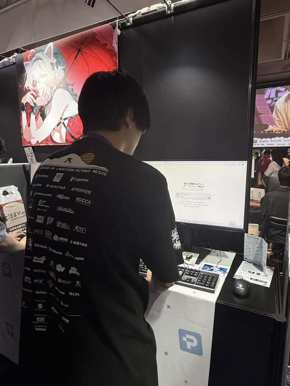 ゲームイベント会場でAIアニメエージェントのデモを体験する来場者
