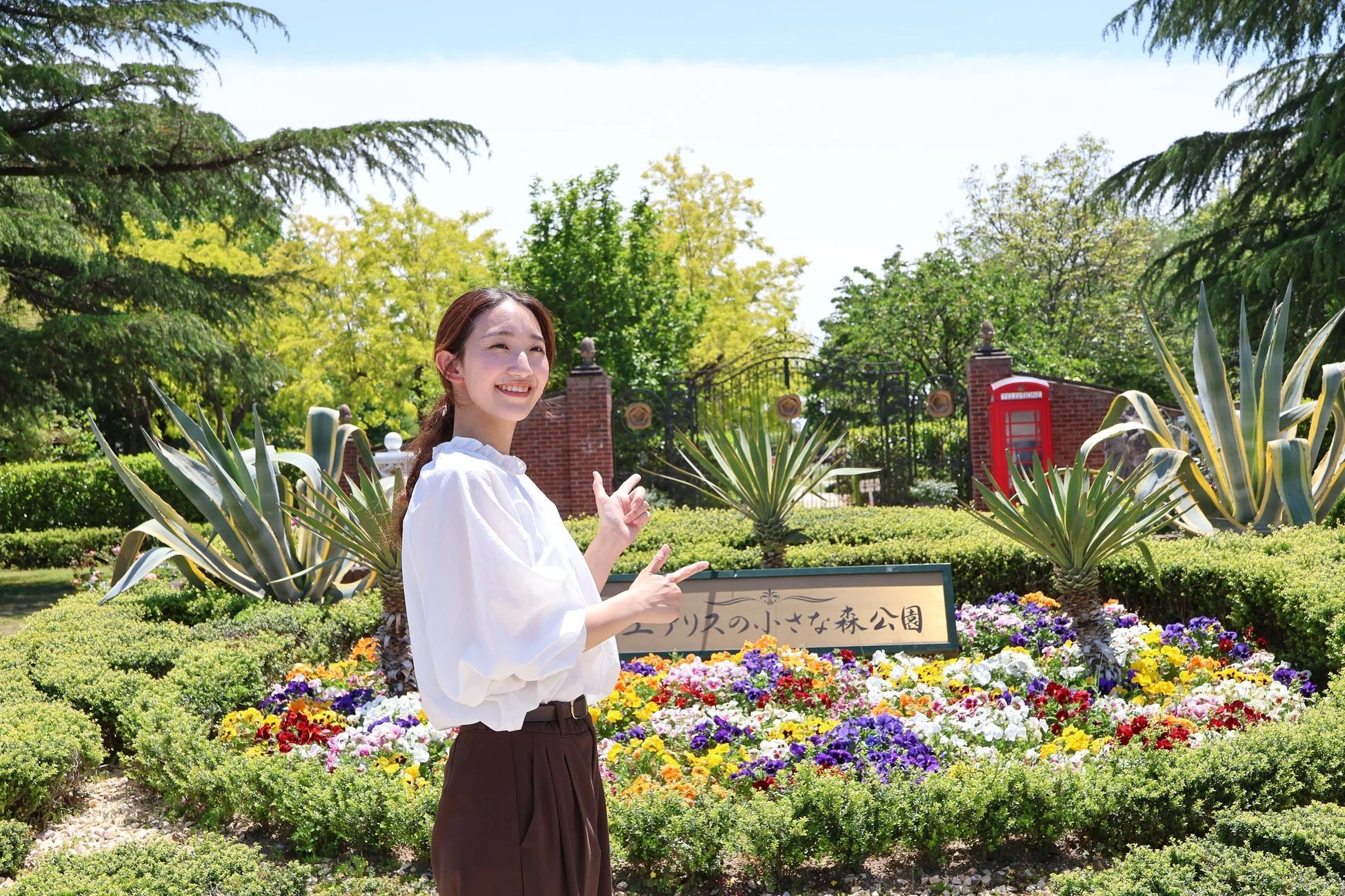 アリスの小さな森公園の看板と笑顔の女性