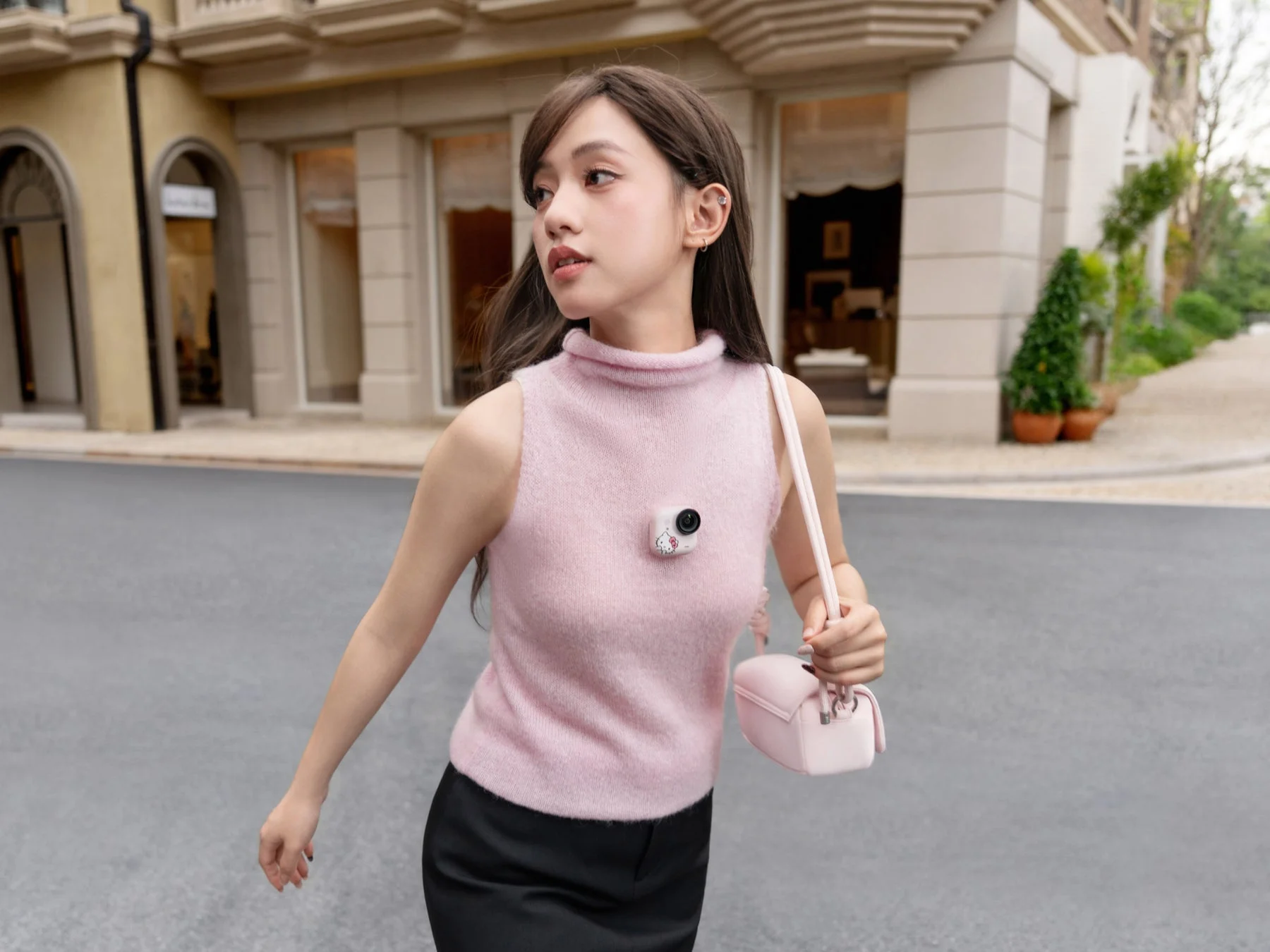 ハローキティデザインの小型カメラを胸元につけた女性
