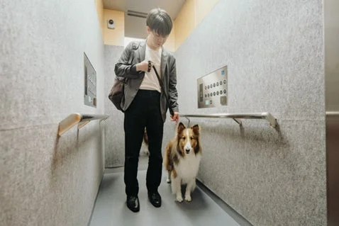エレベーターに乗る男性と犬