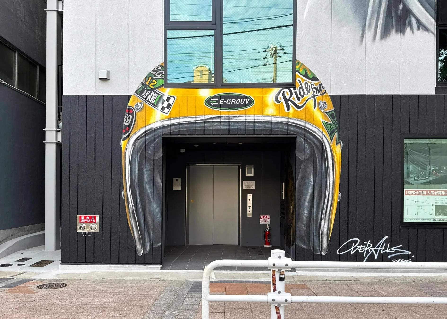 建物の入り口に描かれた巨大な黄色のバイクヘルメットの壁画