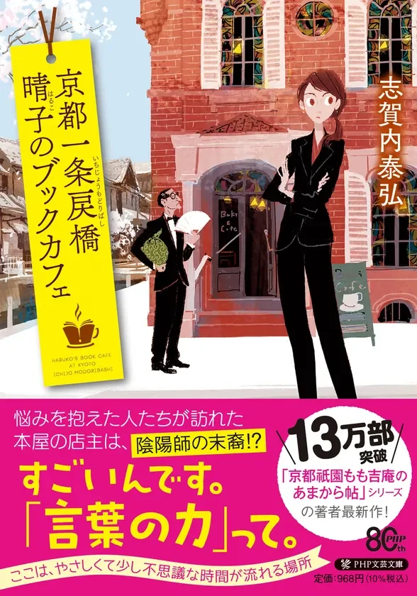 京都の一条戻橋にあるブックカフェを舞台にした小説の表紙です。悩みを抱える人々が訪れるこのカフェの店主は、陰陽師の末裔かもしれないという設定で、「言葉の力」がテーマ。13万部突破した人気シリーズの著者による最新作で、優しく少し不思議な時間が流れる物語です。