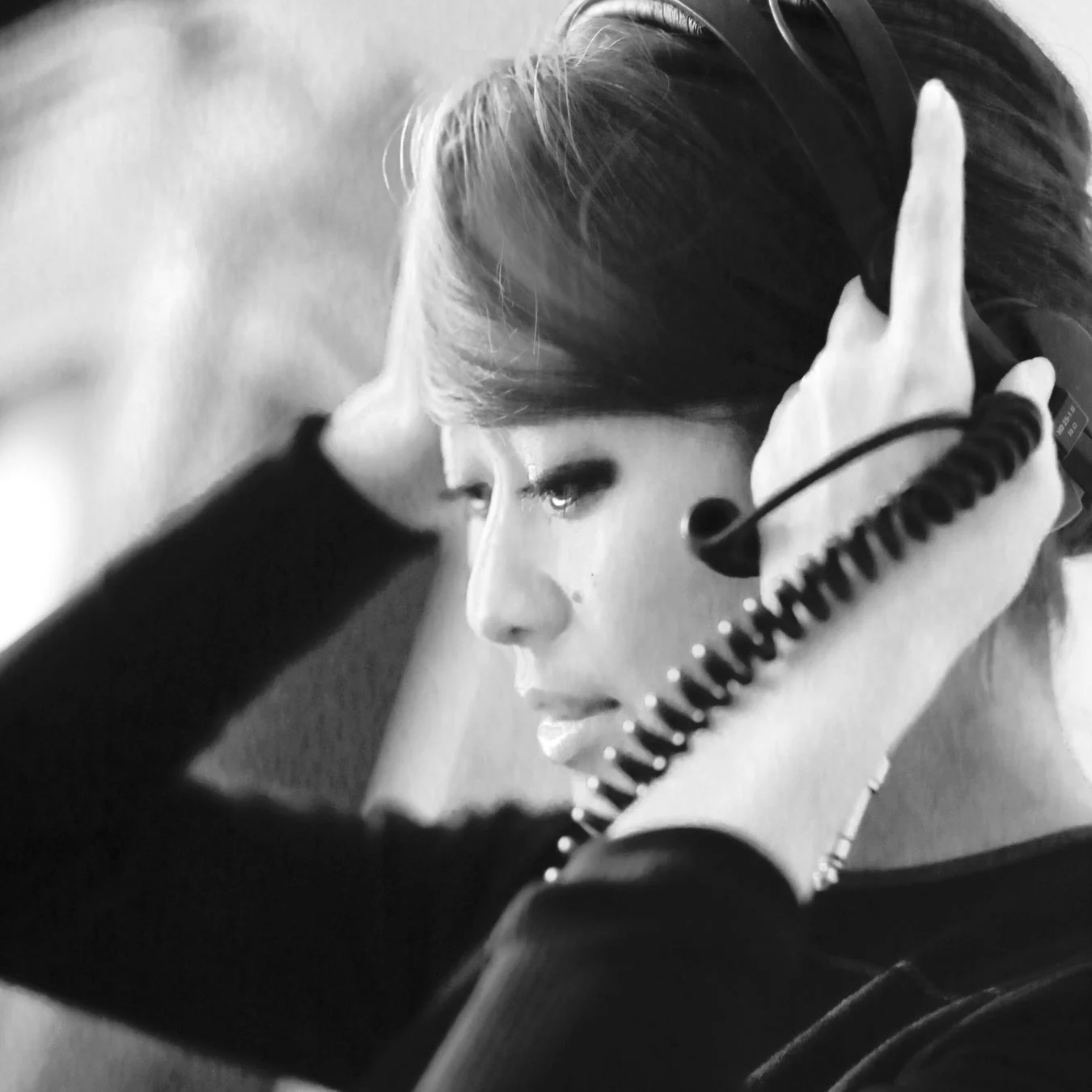モノクロで撮影された、ヘッドホンを装着している女性の横顔のクローズアップ