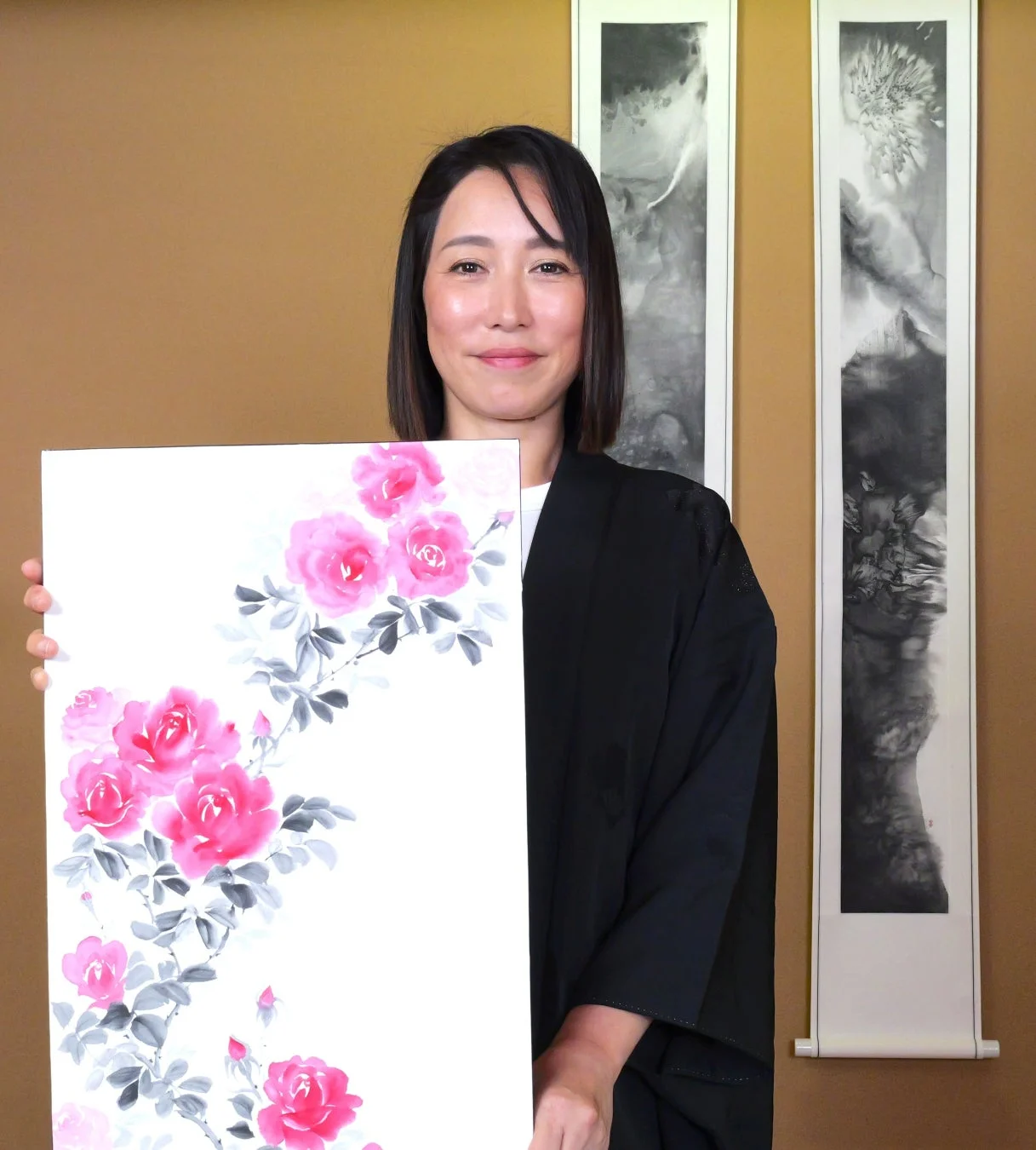墨彩アート作品を持つ講師の女性