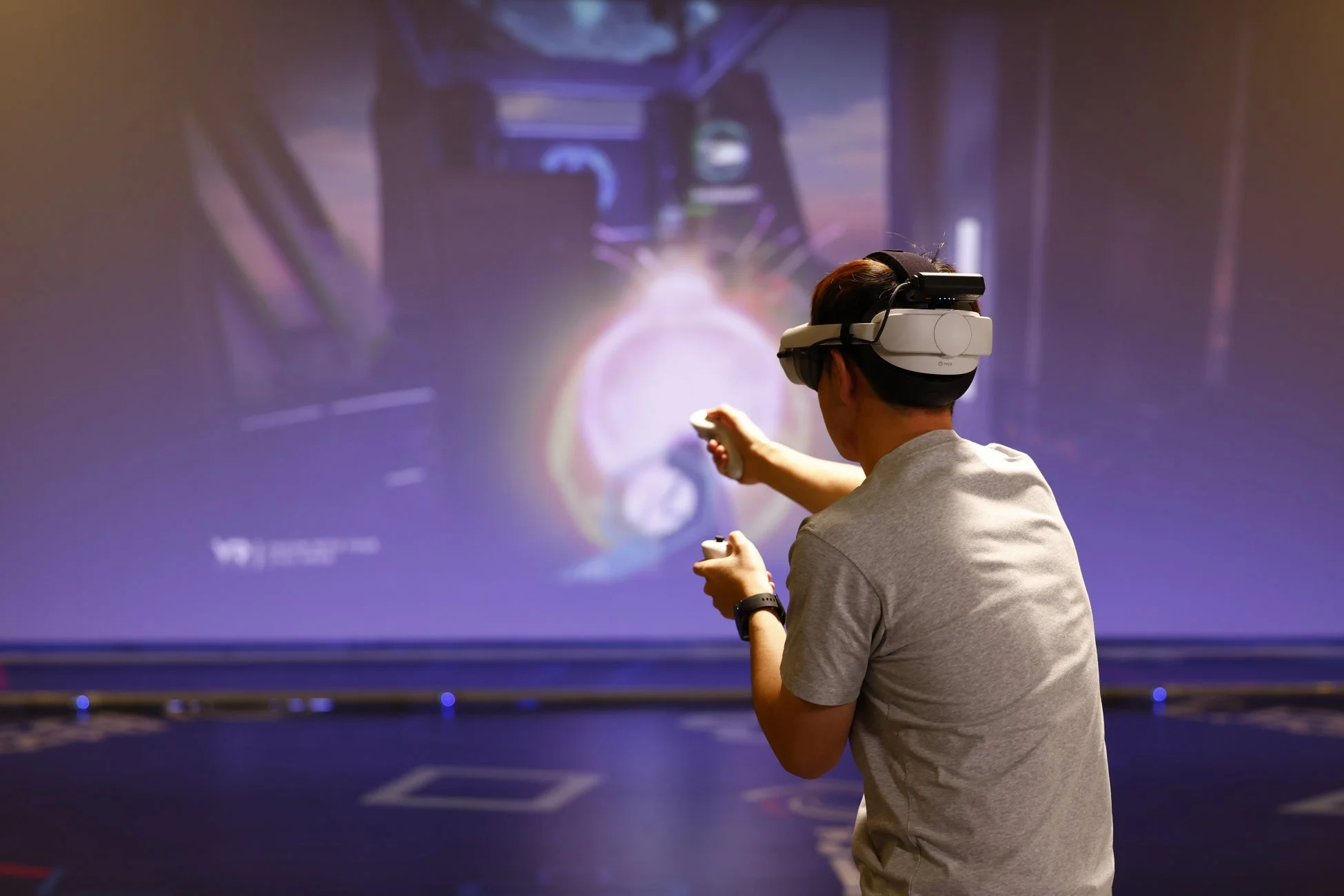 VRヘッドセットを装着してゲームをする人