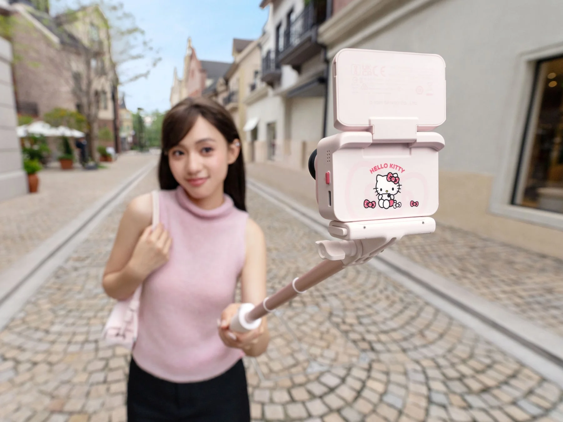 Hello Kittyデザインの自撮り棒を持つ女性