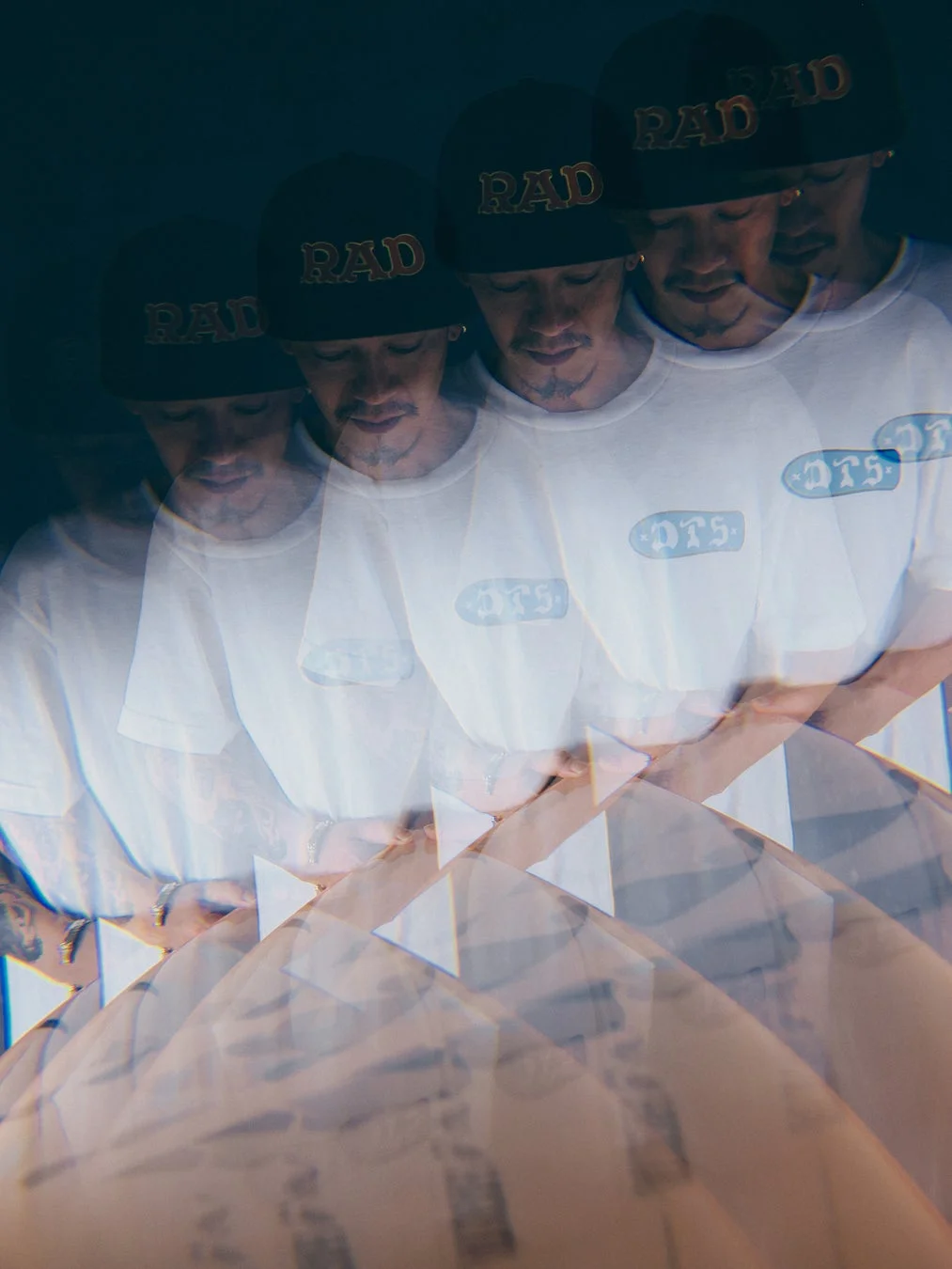 「RAD」の帽子と「DTS」の白いTシャツを着た男性の多重露光写真