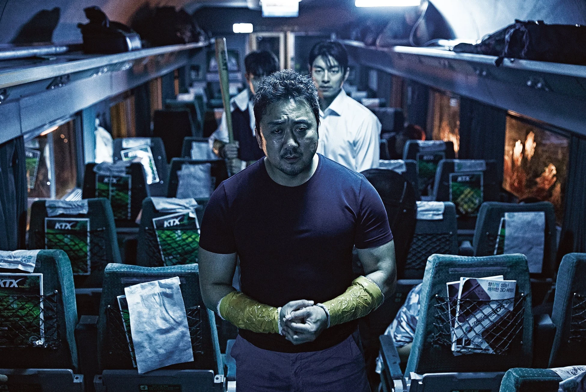 列車内で、腕にプロテクターを巻いた男性が険しい表情で立つ姿