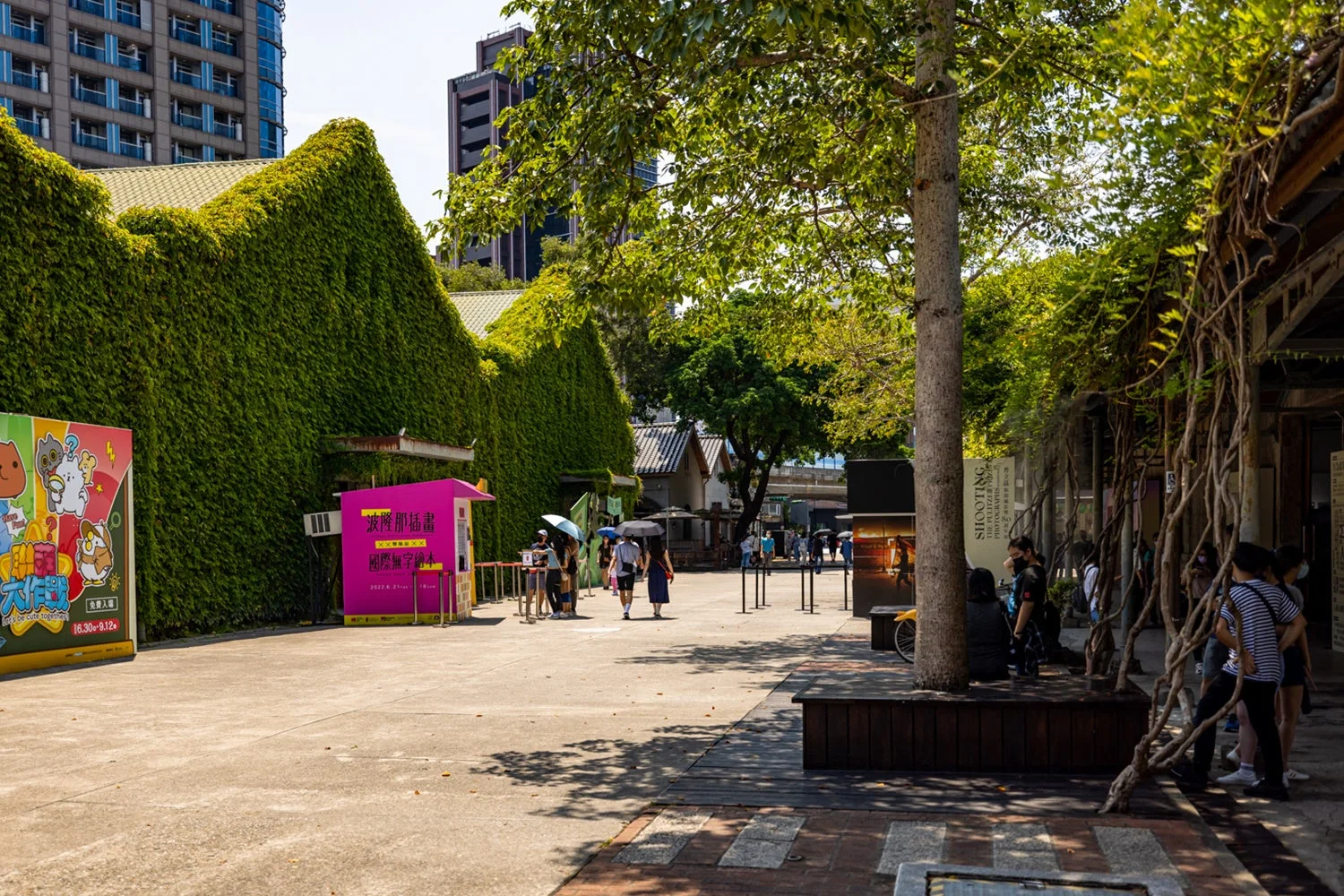 緑のツタで覆われた建物が印象的な屋外広場の風景