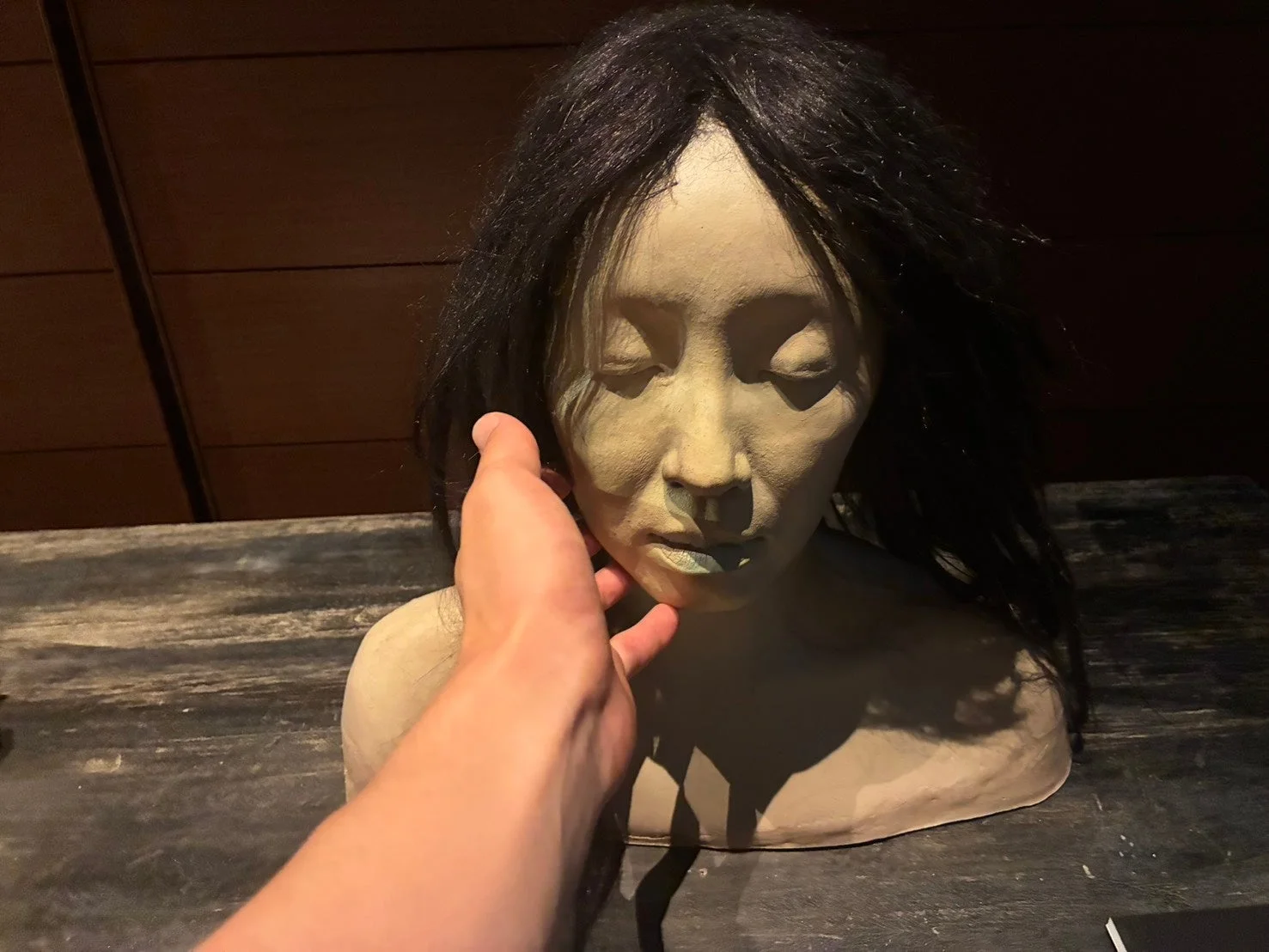 女性の彫像に触れる手