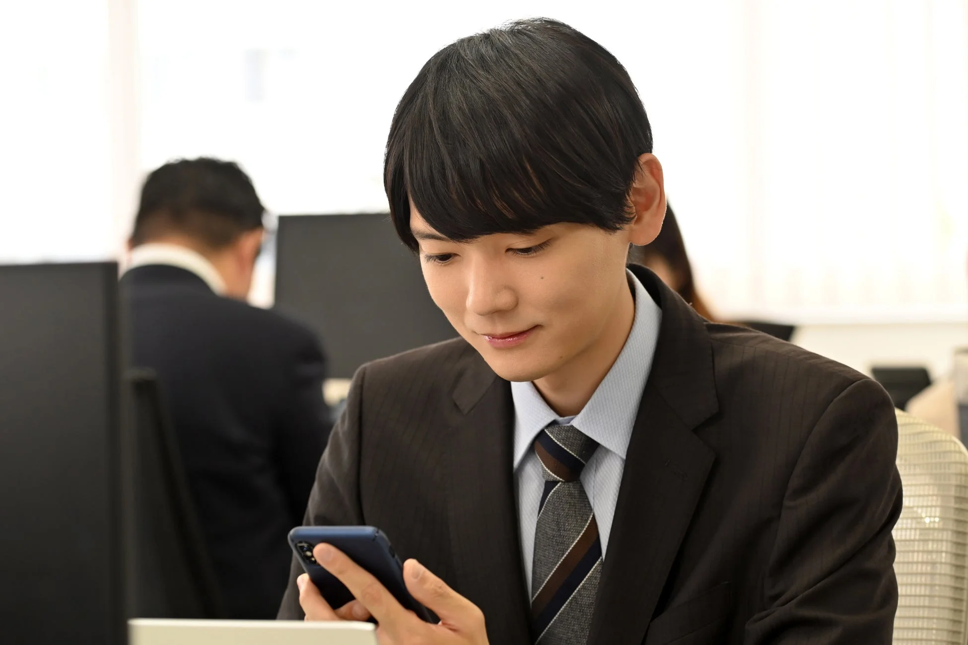スマートフォンを操作するスーツ姿の男性