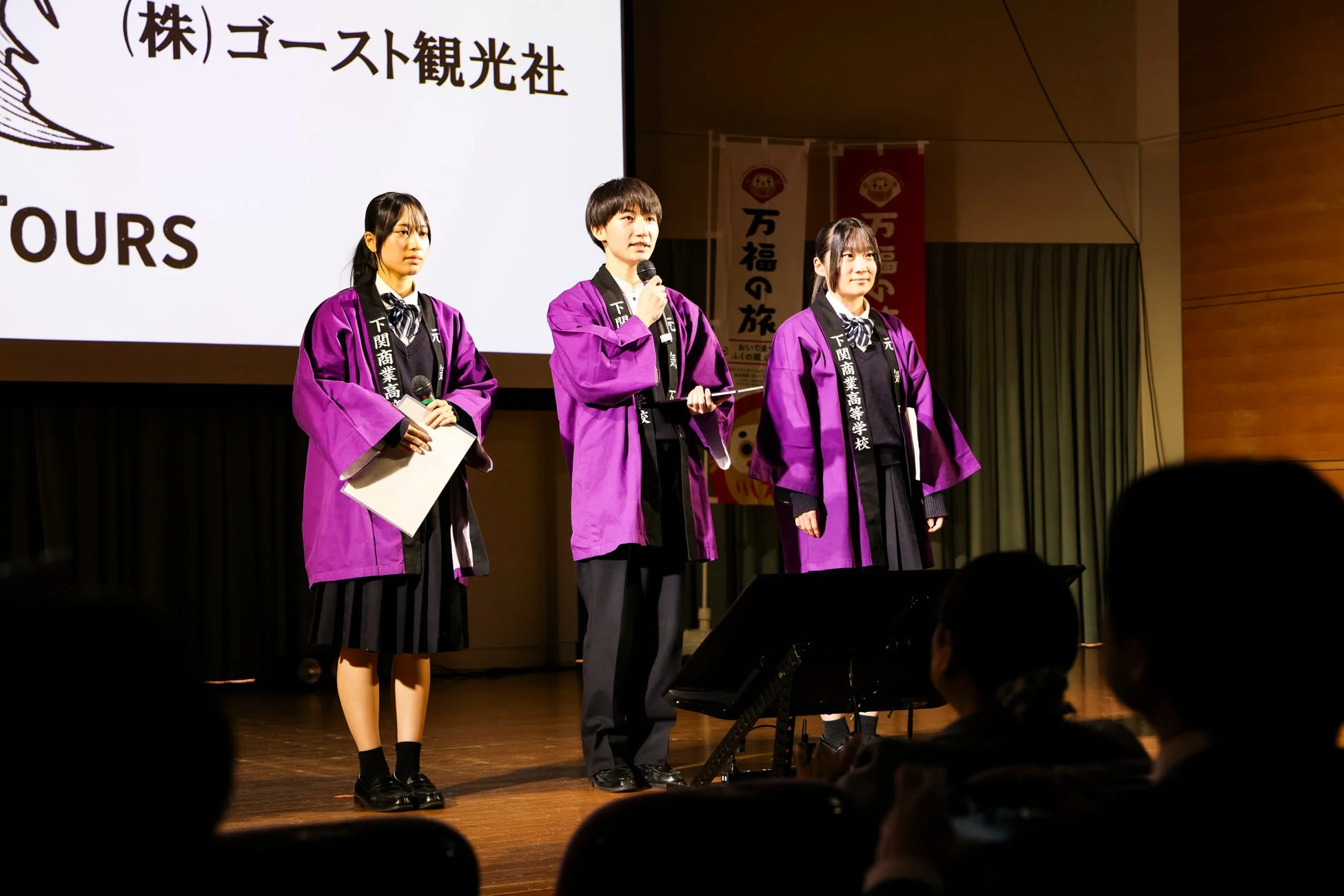 ステージでプレゼンテーションを行う高校生