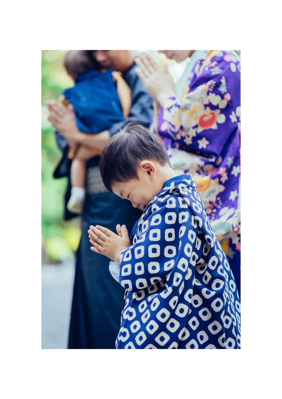 日本の伝統的な衣装を身につけた家族がお参りをしている様子
