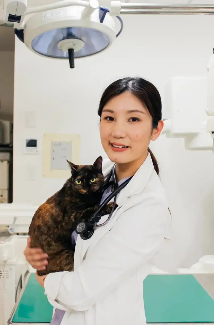 猫を抱き笑顔を見せる獣医師