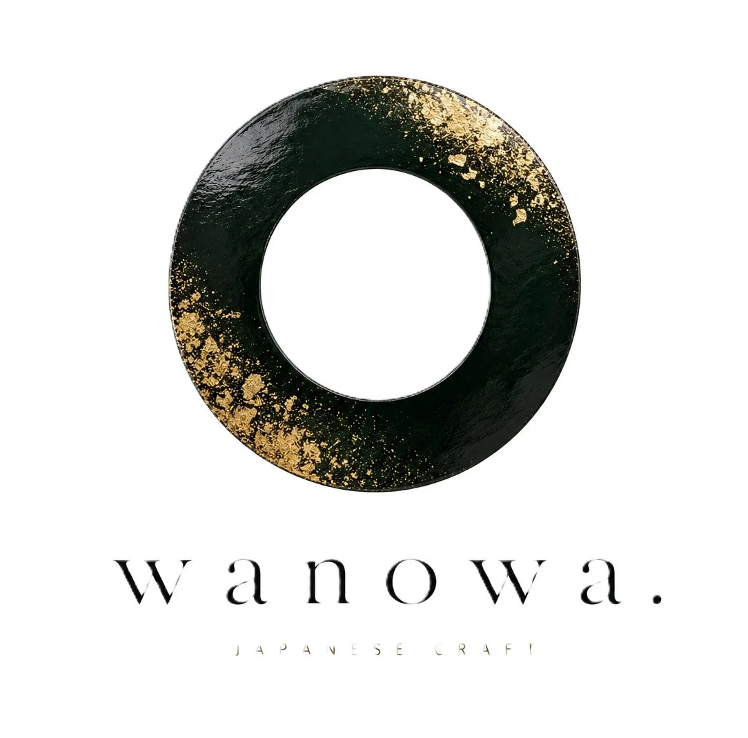 黒い円形のオブジェクトに金箔が散りばめられ、その下に「wanowa. JAPANESE CRAFT」と書かれたロゴデザイン