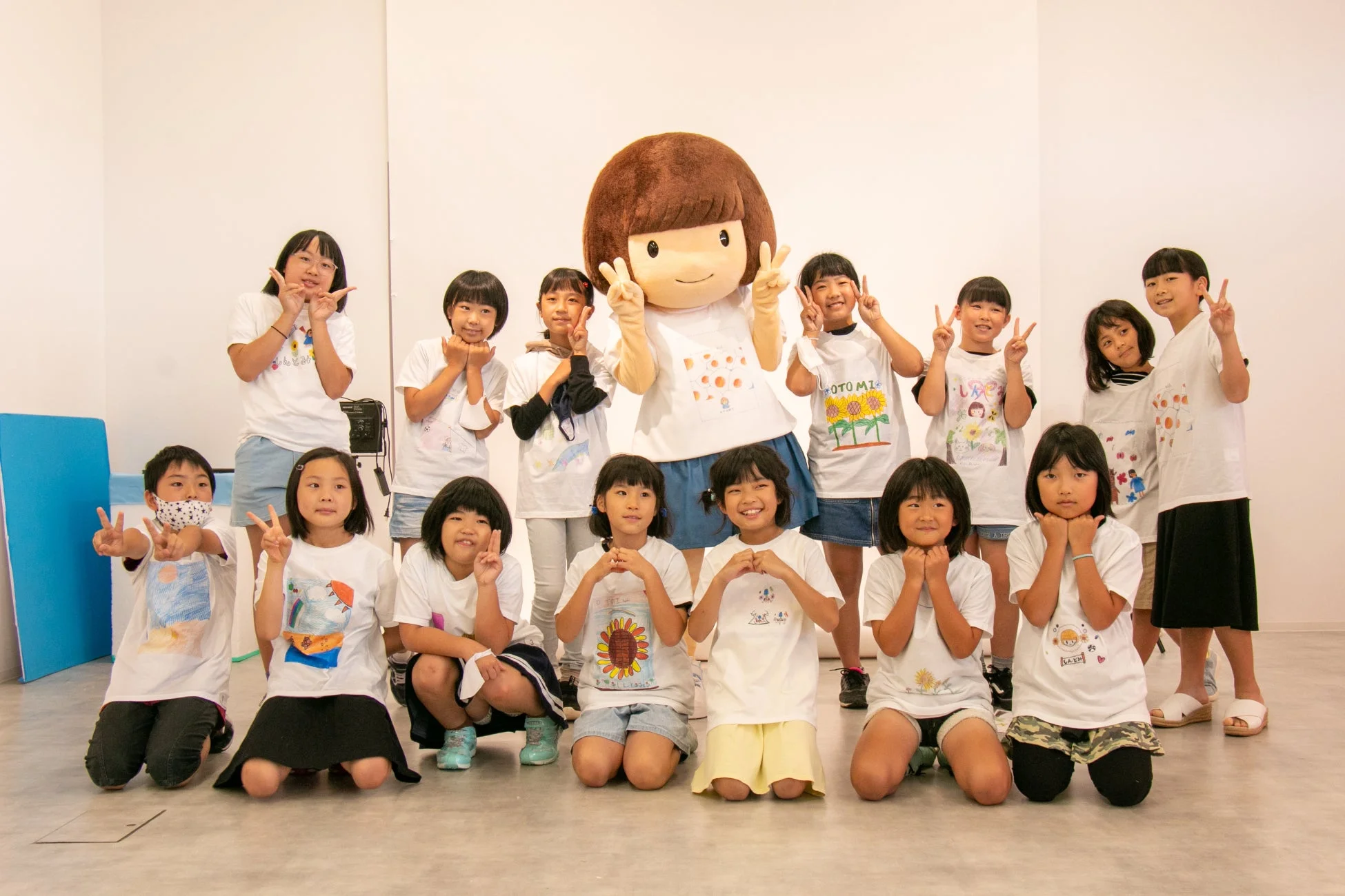 マスコットキャラクターと一緒に集合写真を撮る子供たち