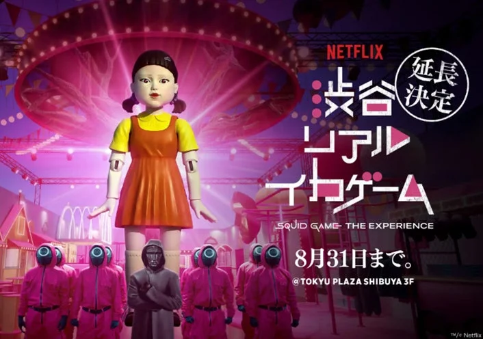 Netflixが提供する「SQUID GAME: THE EXPERIENCE」の渋谷でのイベント告知画像です。巨大なヨンヒ人形とピンクのジャージを着た警備員が特徴で、イベントは東急プラザ渋谷3Fで8月31日まで延長開催されることが示されています。