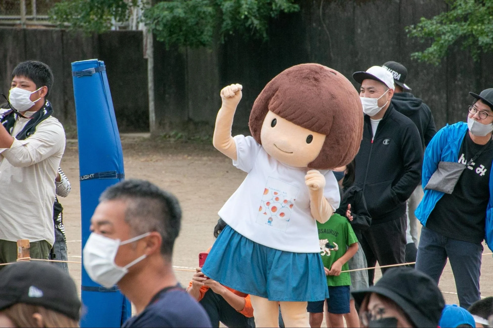 屋外イベントで元気いっぱいのポーズをとるゆるキャラ