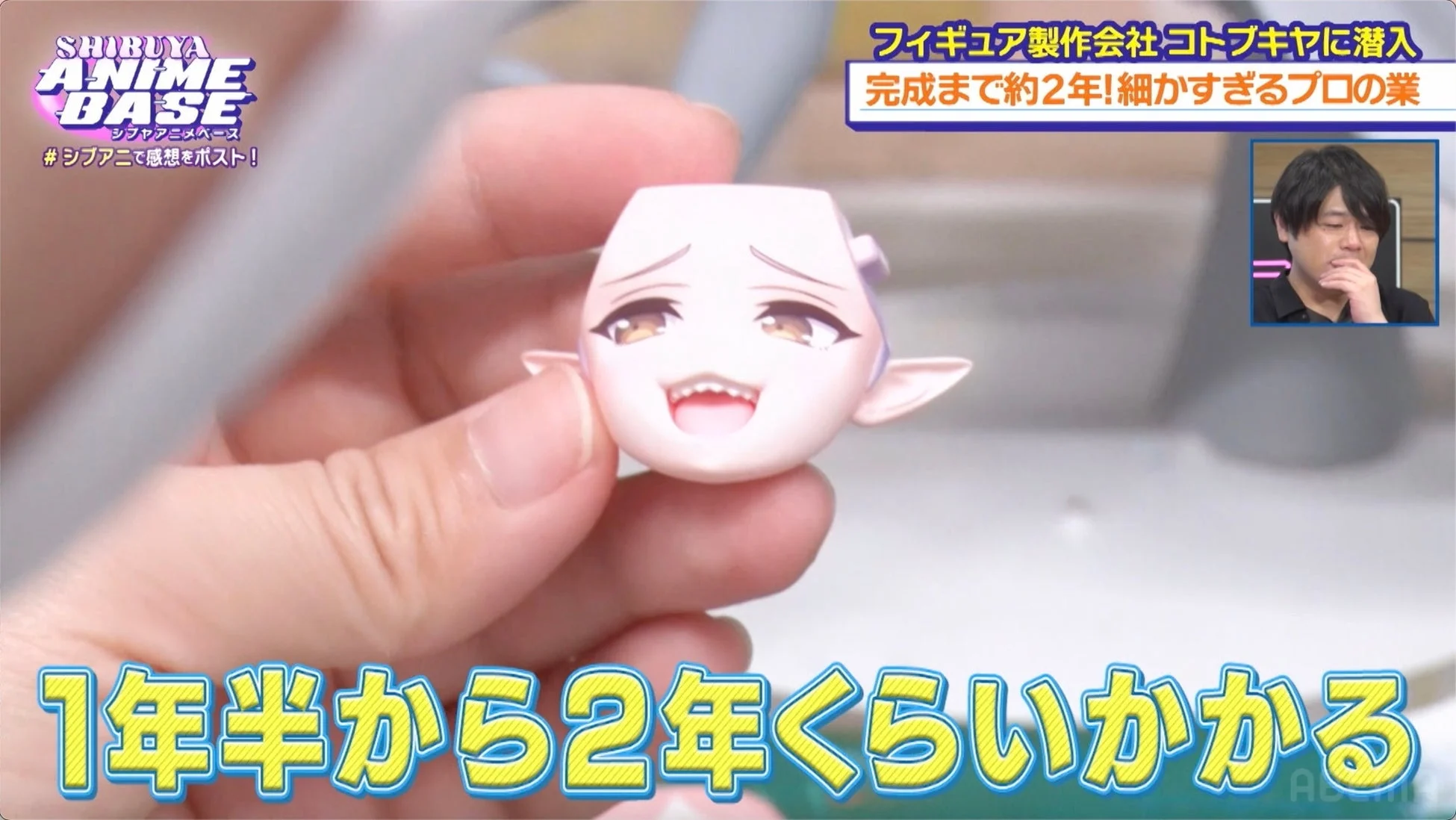 フィギュアの顔パーツを手に取るスタッフ