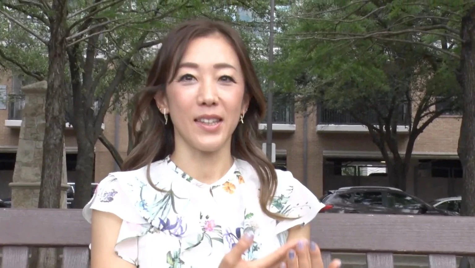 屋外のベンチに座って微笑むアジア人女性のポートレート
