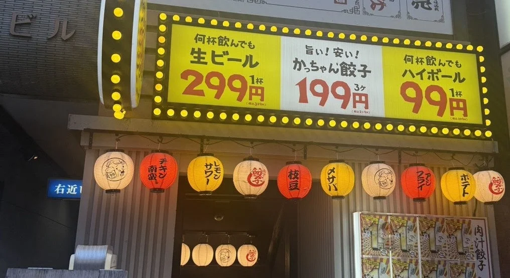 居酒屋の賑やかな店先、生ビールやハイボールの格安価格を提示する電飾看板