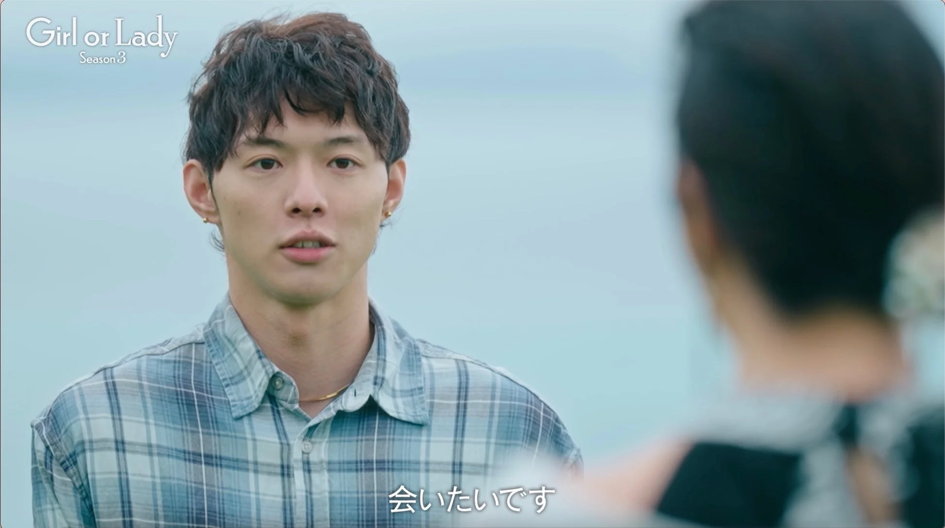 チェックシャツを着た男性が真剣な表情で話す様子