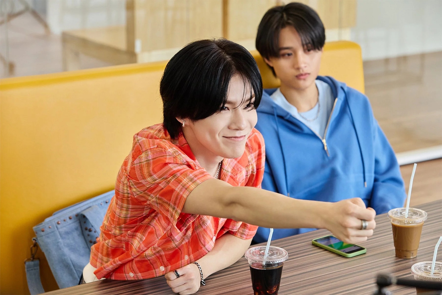 カフェでくつろぐ二人の若い男性が写っています。