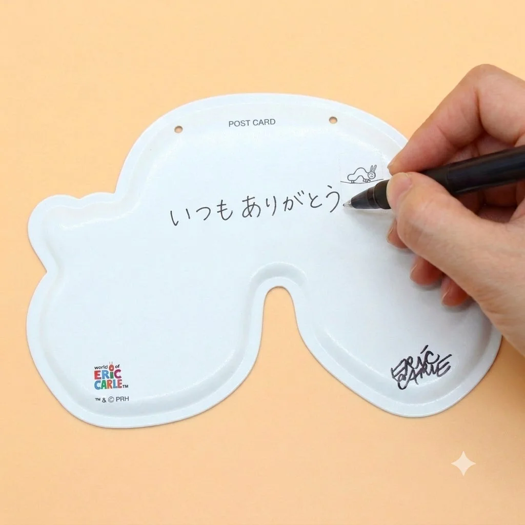 ポストカードにメッセージを手書きする様子