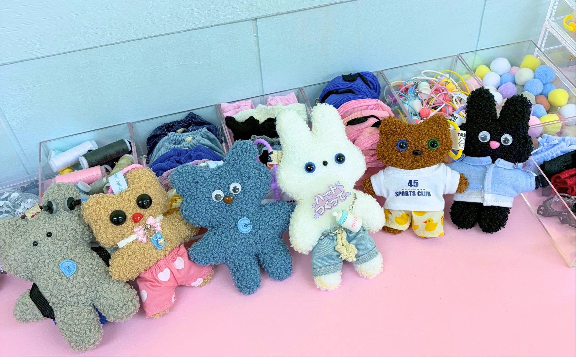 様々な衣装をまとった可愛いクマやウサギのぬいぐるみキーホルダーと裁縫用品