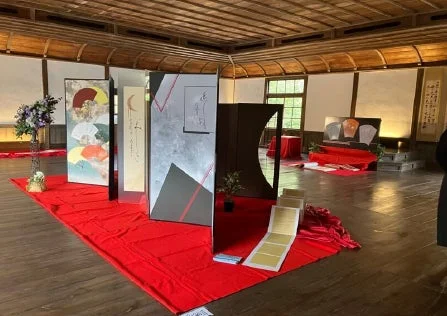 伝統的な和室で、抽象的な絵画や書道が描かれた複数の屏風やパネルが展示されている