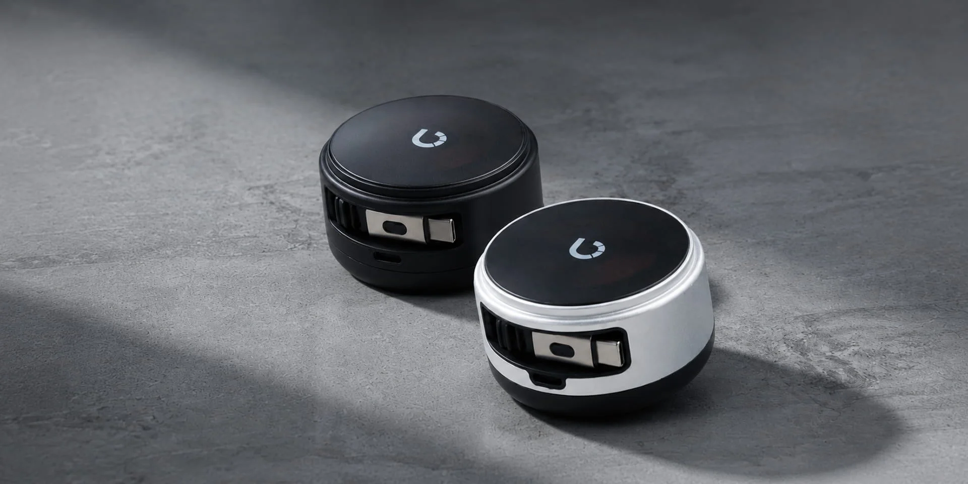 黒と白の2つの丸いコンパクトな電子機器