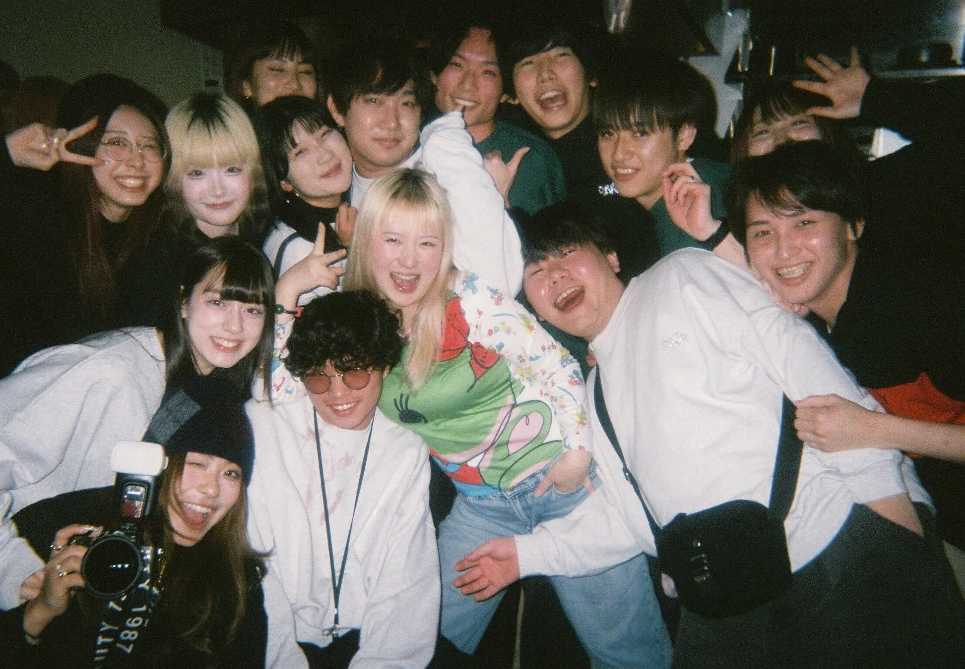 大勢の若者たちが笑顔で集まり、楽しそうにポーズを取っている集合写真