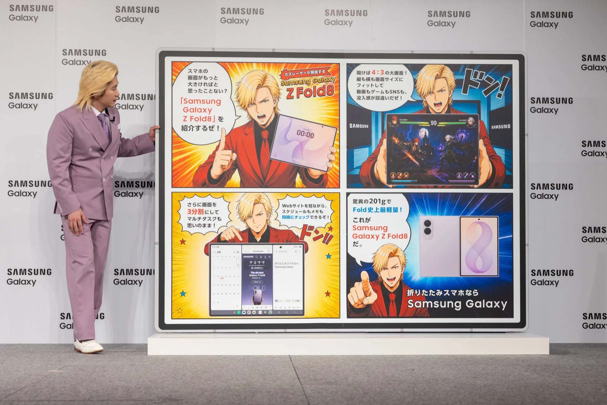 巨大なSamsung Galaxy Z Fold8オブジェを指差すカズレーザーさん
